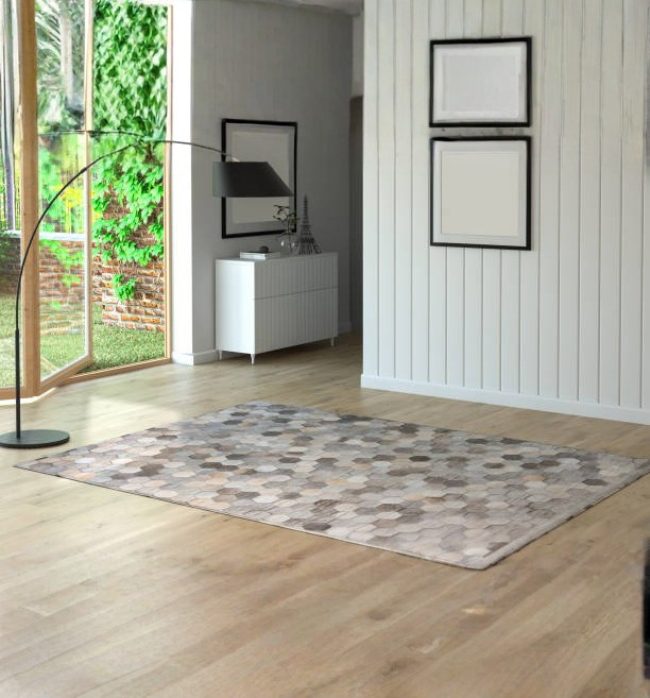 Light-colored area rug placed on clean hardwood floors in a bright living room, highlighting a fresh, well-maintained space after hardwood cleaning