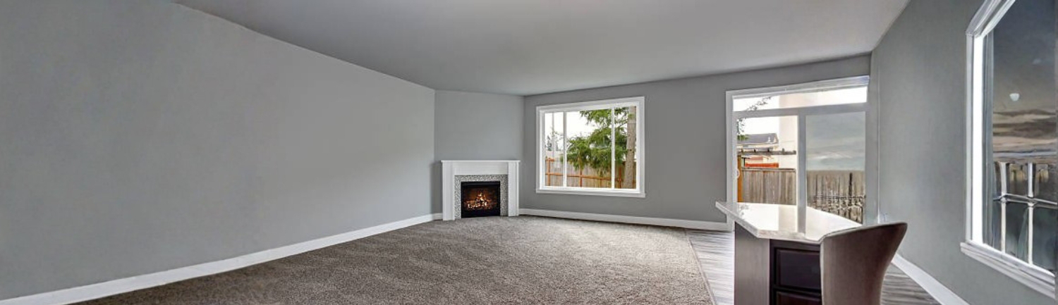 Spacious living room with freshly cleaned carpet, showing a bright, refreshed interior after residential carpet cleaning