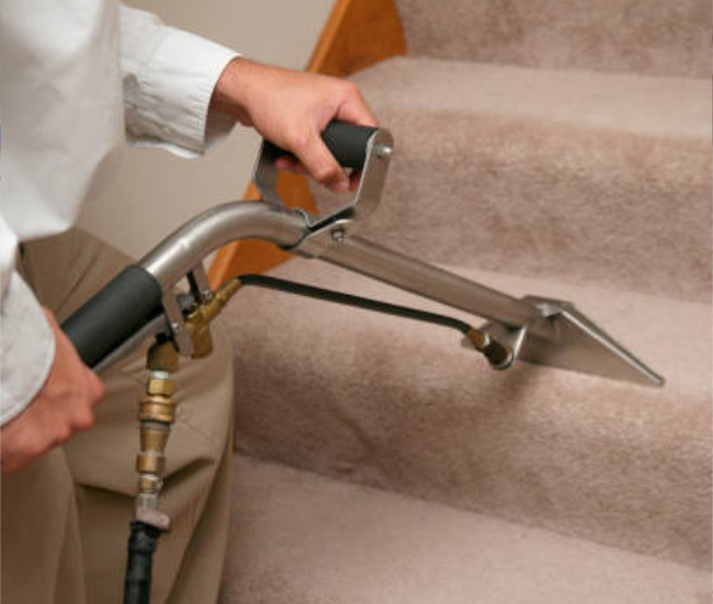 Close-up view of carpet cleaning being performed on a staircase, with extraction equipment lifting deep dirt, stains, and debris from carpet fibers