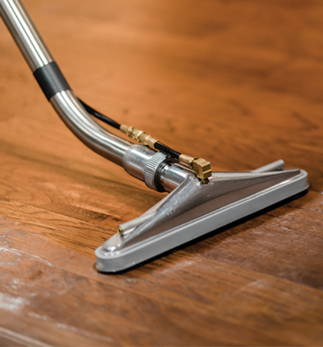 Close-up of hardwood cleaning equipment gently extracting residue from wood floors, improving cleanliness and overall floor appearance