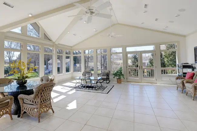 Spacious, light-filled living area with freshly cleaned tile floors, white grout lines, and elegant seating, showcasing expert tile and grout cleaning for a clean, polished residential interior