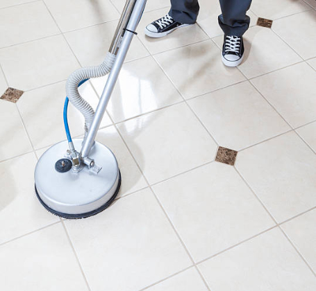 Professional tile and grout cleaning service using a rotary floor scrubber on light-colored ceramic tiles, removing embedded dirt and restoring shine to the floor